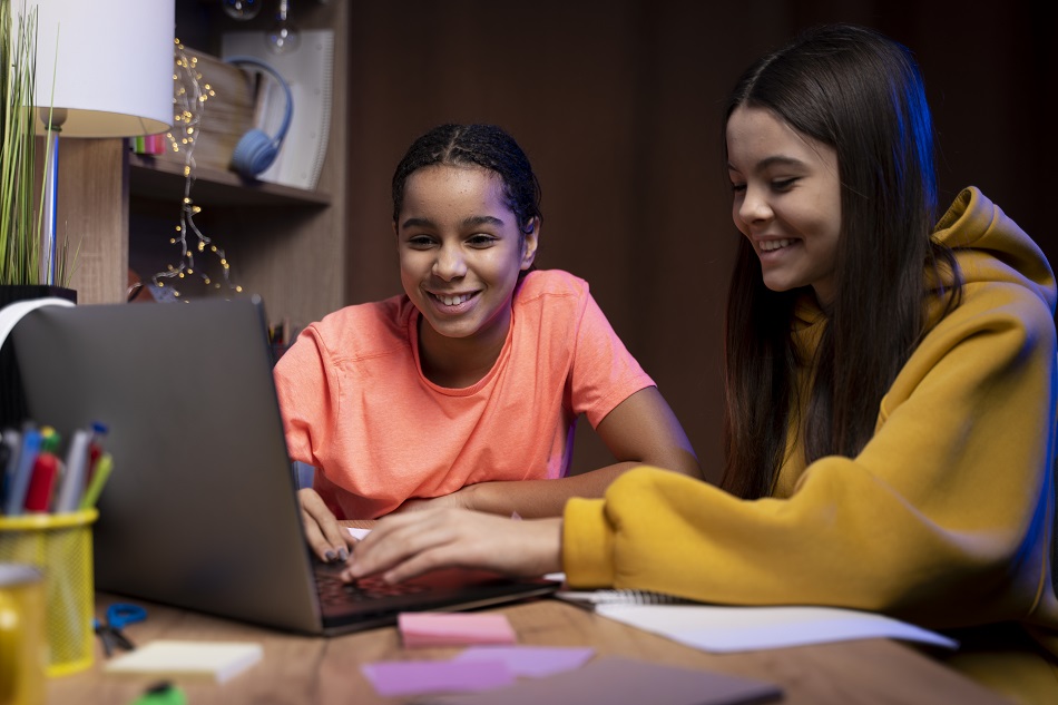 two-teenage-girls-studying-together-home-laptop